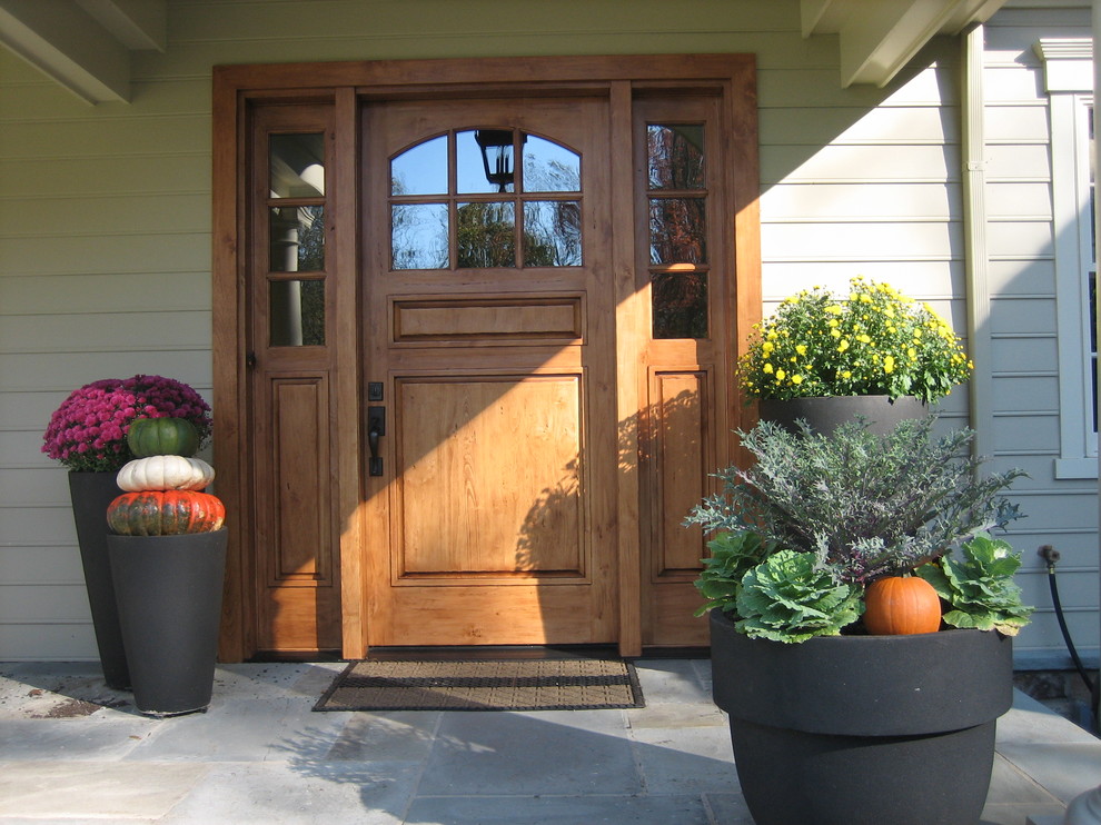 This is an example of a traditional entryway in Philadelphia with a single front door and a medium wood front door.