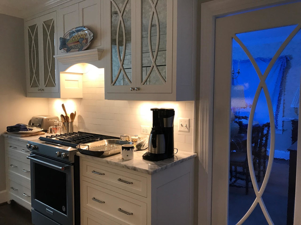 Inspiration for a mid-sized transitional l-shaped brown floor and dark wood floor enclosed kitchen remodel in DC Metro with an undermount sink, shaker cabinets, white cabinets, marble countertops, white backsplash, subway tile backsplash, paneled appliances and an island