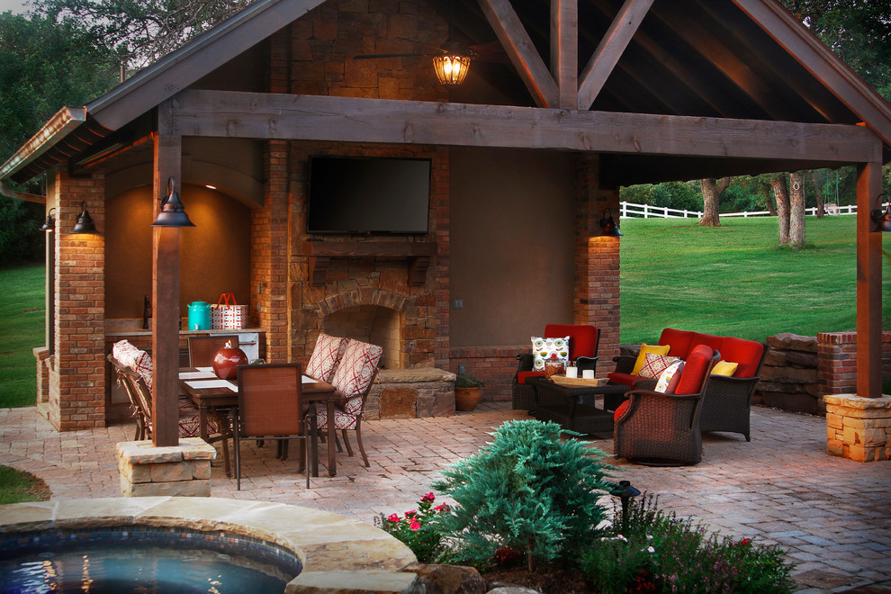 Photo of a traditional patio in Oklahoma City with brick pavers, a gazebo/cabana and with fireplace.