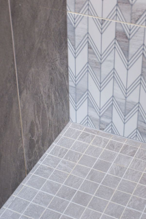 Corner shower - transitional master multicolored tile vinyl floor, brown floor and double-sink corner shower idea with shaker cabinets, white cabinets, blue walls, an undermount sink, quartz countertops, a hinged shower door, white countertops and a built-in vanity