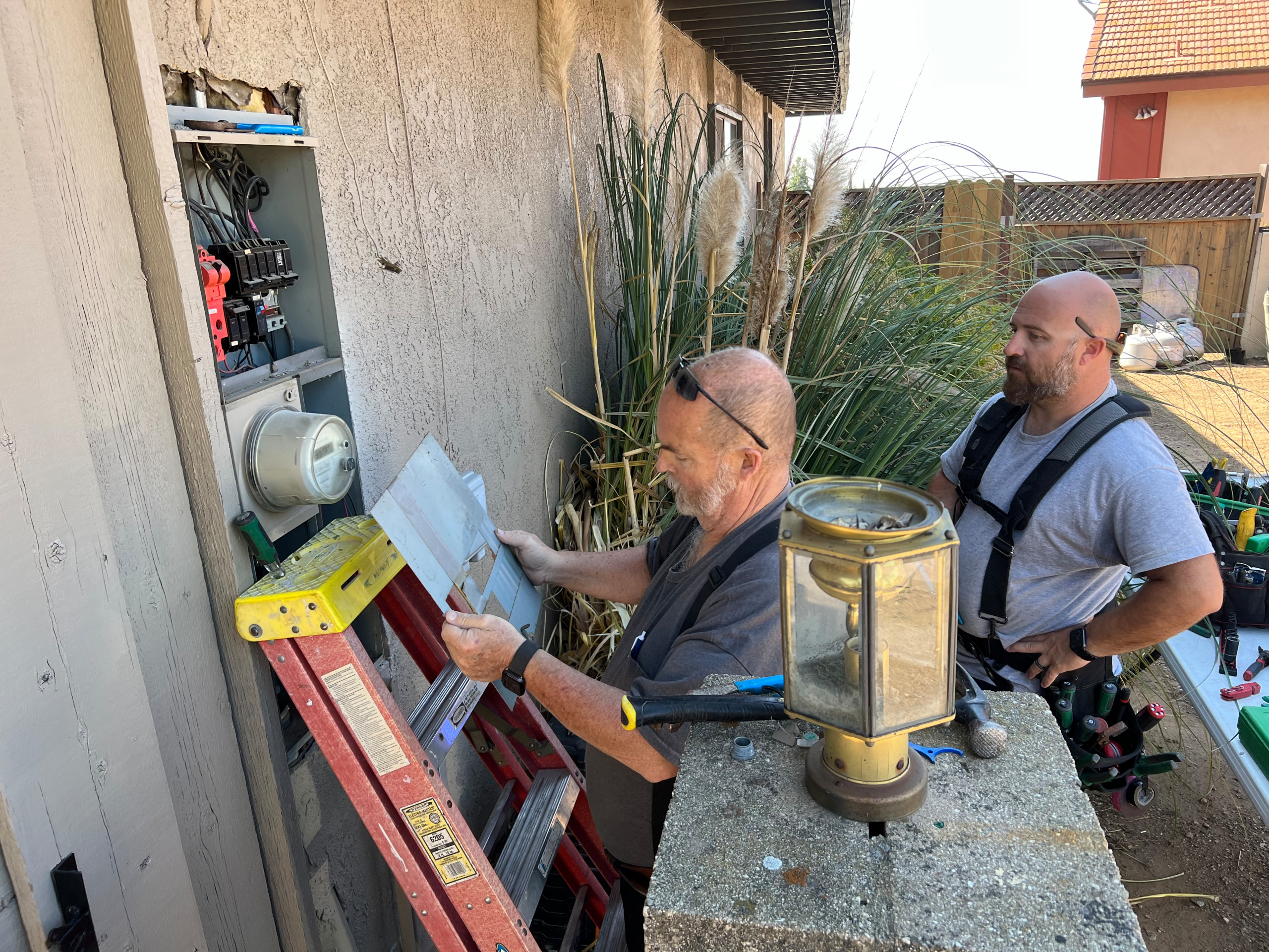 Father and son inspecting electrical panel