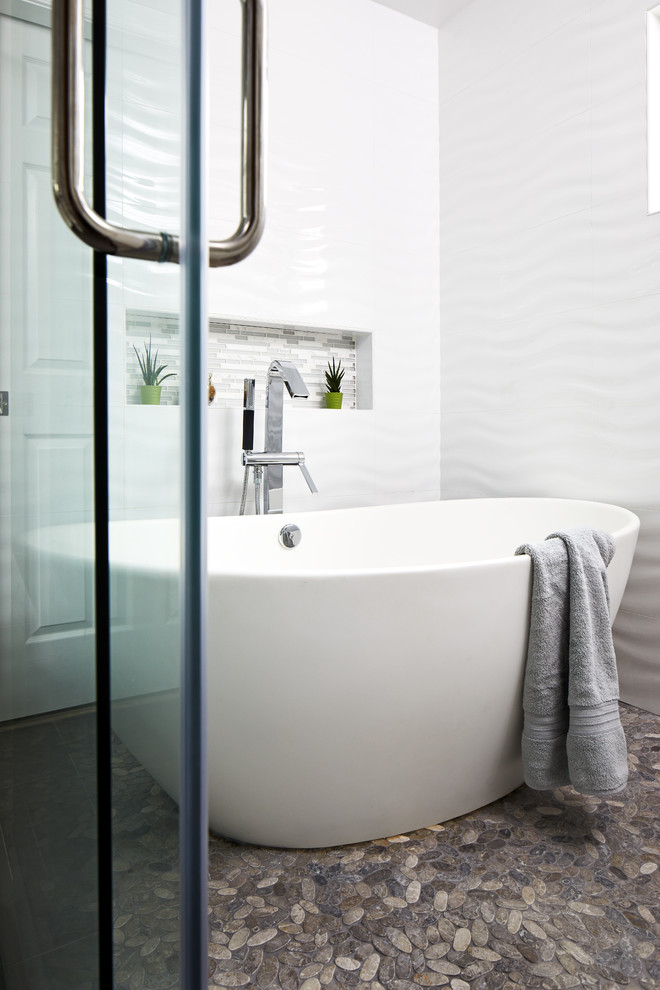 Inspiration for a mid-sized modern master wet room bathroom in Chicago with flat-panel cabinets, white cabinets, a freestanding tub, a one-piece toilet, white tile, ceramic tile, grey walls, porcelain floors, an undermount sink, engineered quartz benchtops, grey floor, a sliding shower screen and grey benchtops.