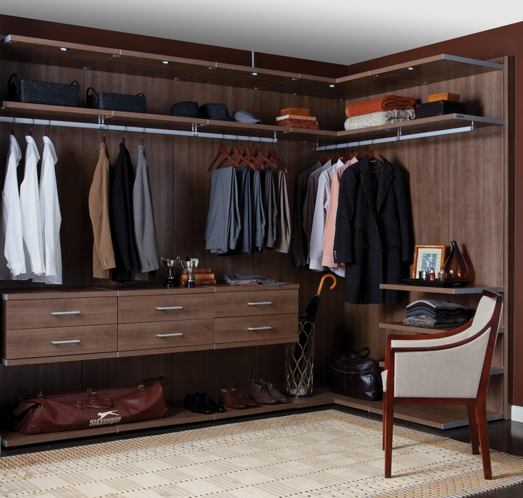 Large contemporary men's walk-in wardrobe in Hawaii with flat-panel cabinets and dark wood cabinets.