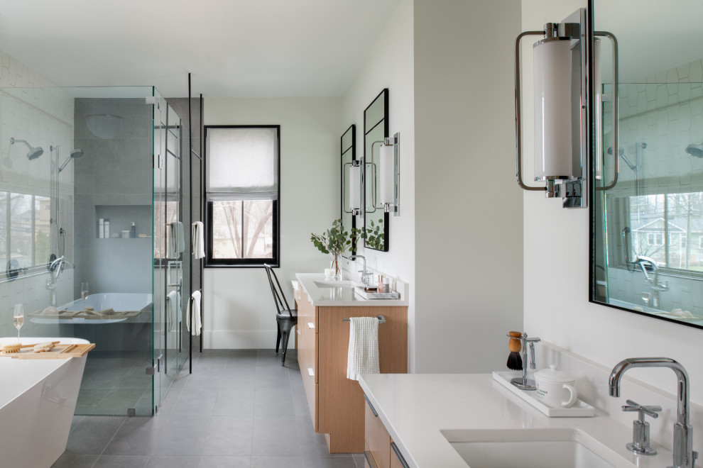 Inspiration for a medium sized contemporary ensuite bathroom in DC Metro with light wood cabinets, a freestanding bath, a built-in shower, porcelain flooring, a submerged sink, engineered stone worktops, grey floors, a hinged door, white worktops, a shower bench, double sinks and a built in vanity unit.