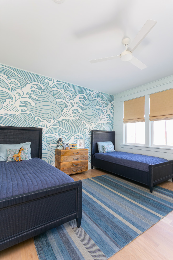 Réalisation d'une chambre d'enfant de 4 à 10 ans marine avec un mur bleu, un sol en bois brun, un sol marron et du papier peint.