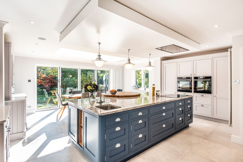 Inspiration for a transitional u-shaped eat-in kitchen in Hampshire with an undermount sink, shaker cabinets, black appliances, with island, grey cabinets, granite benchtops, grey floor and grey benchtop.