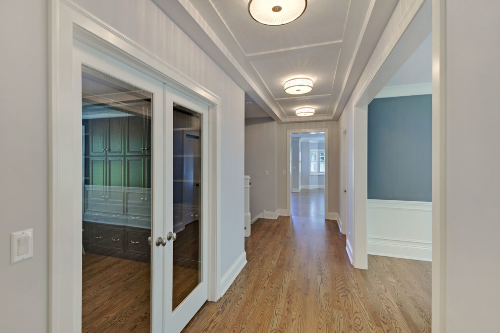 Photo of a mid-sized transitional hallway in Chicago with grey walls and light hardwood floors.