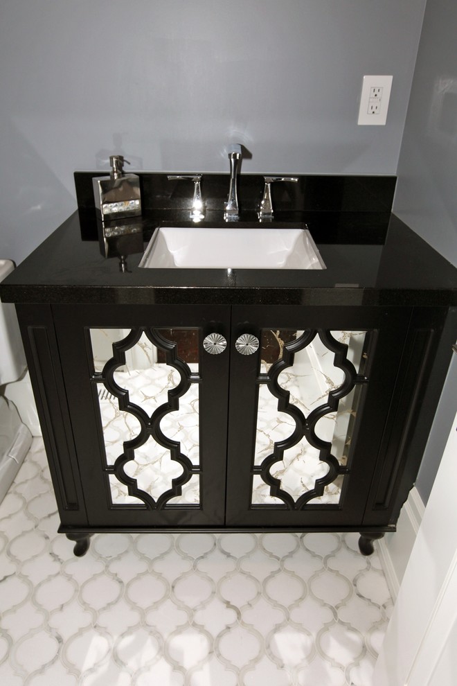 Design ideas for a small transitional powder room in Toronto with recessed-panel cabinets, black cabinets, a two-piece toilet, grey walls, porcelain floors, an undermount sink, solid surface benchtops and white floor.