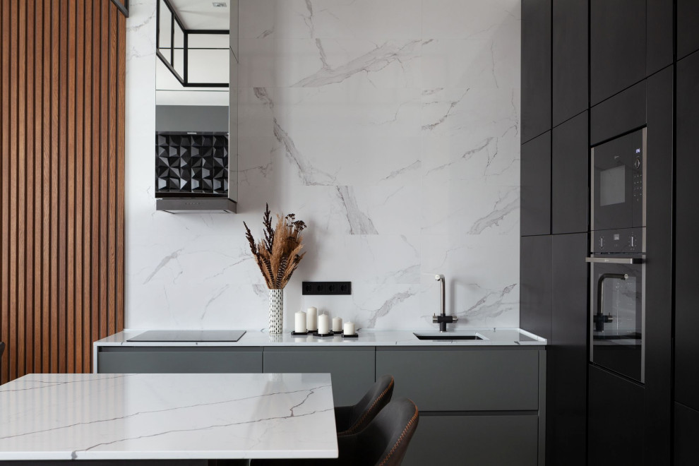 Inspiration for a mid-sized contemporary l-shaped open plan kitchen in Moscow with an undermount sink, flat-panel cabinets, grey cabinets, quartz benchtops, white splashback, porcelain splashback, black appliances, porcelain floors, with island, white floor and white benchtop.