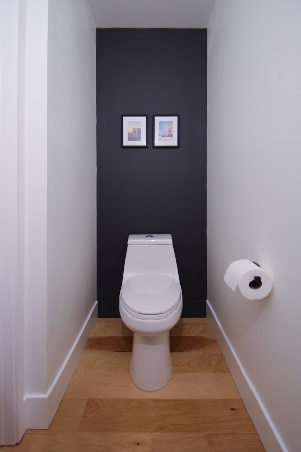 Inspiration för ett litet funkis grå grått toalett, med svarta skåp, en toalettstol med hel cisternkåpa, vit kakel, porslinskakel, vita väggar, mellanmörkt trägolv, ett undermonterad handfat, bänkskiva i betong och flerfärgat golv