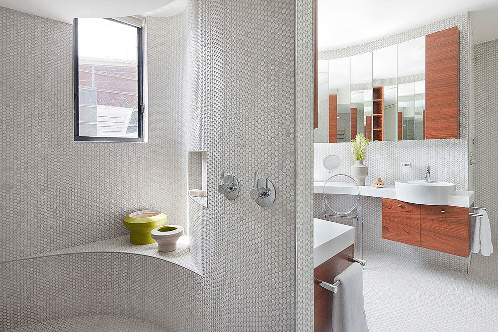 Inspiration for a large contemporary master bathroom in Melbourne with flat-panel cabinets, medium wood cabinets, solid surface benchtops, an open shower, a wall-mount toilet, white tile, mosaic tile, beige walls, mosaic tile floors and a drop-in sink.