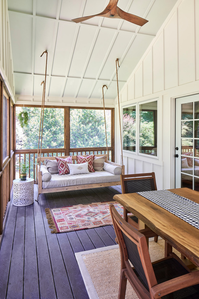 Photo of a mid-sized country backyard screened-in verandah in Charlotte with a roof extension and wood railing.