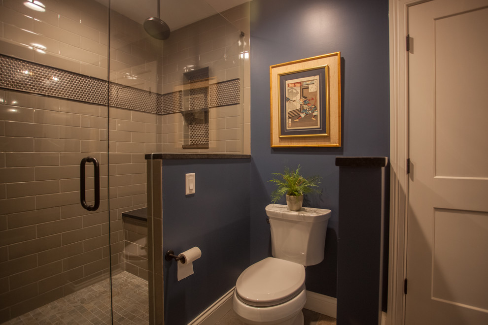 Design ideas for a large transitional master bathroom in Cincinnati with flat-panel cabinets, distressed cabinets, a corner shower, a one-piece toilet, blue walls, ceramic floors, a drop-in sink, granite benchtops, brown floor, a hinged shower door and brown benchtops.