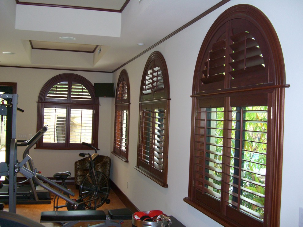Photo of a large traditional home weight room in Miami with white walls and concrete floors.