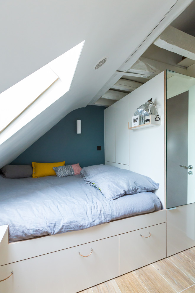 Small contemporary loft-style bedroom in Paris with blue walls, ceramic floors and no fireplace.