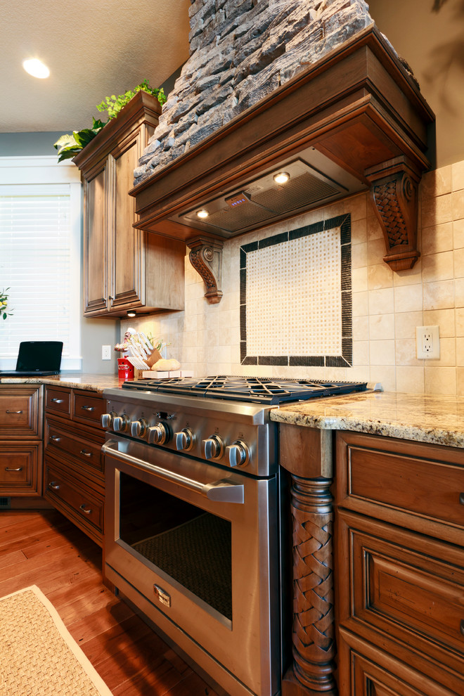 Kitchen - transitional kitchen idea with an undermount sink, raised-panel cabinets, medium tone wood cabinets, granite countertops, stone tile backsplash and paneled appliances