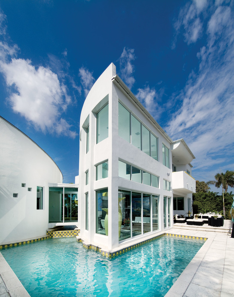 Design ideas for a contemporary two-storey glass white exterior in Miami with a flat roof.
