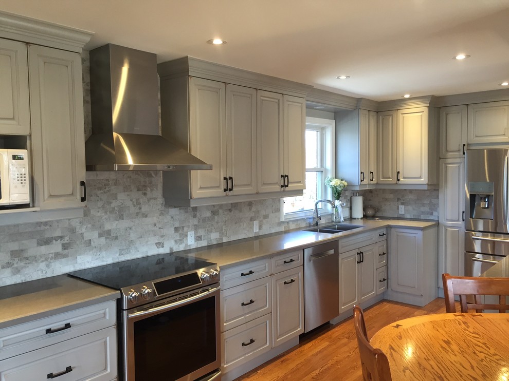 Example of a country medium tone wood floor kitchen design in Toronto with raised-panel cabinets, distressed cabinets, quartz countertops and stone tile backsplash