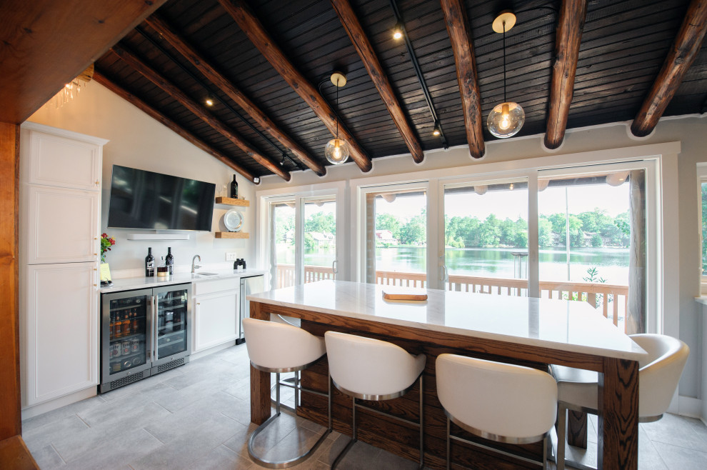Photo of a mid-sized traditional u-shaped eat-in kitchen in Philadelphia with an undermount sink, recessed-panel cabinets, white cabinets, quartzite benchtops, white splashback, ceramic splashback, stainless steel appliances, porcelain floors, with island, beige floor and white benchtop.