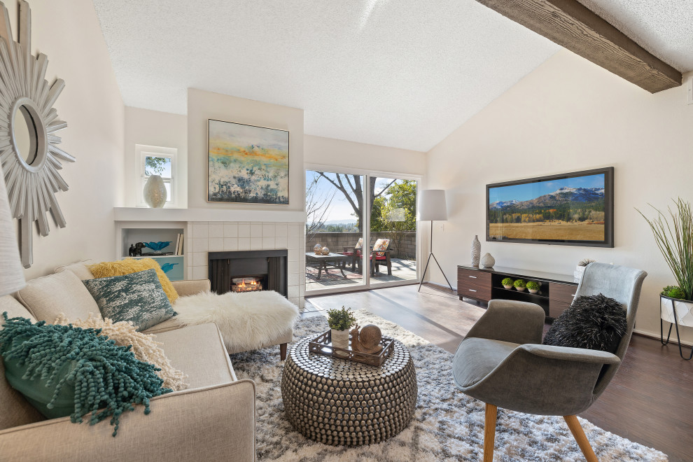 Example of a small transitional laminate floor and exposed beam living room design in Los Angeles with white walls, a corner fireplace, a tile fireplace and a wall-mounted tv