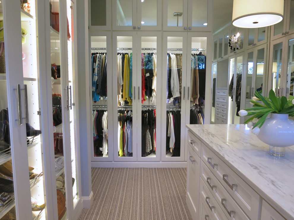 Photo of an expansive women's walk-in wardrobe in Atlanta with flat-panel cabinets, white cabinets and carpet.