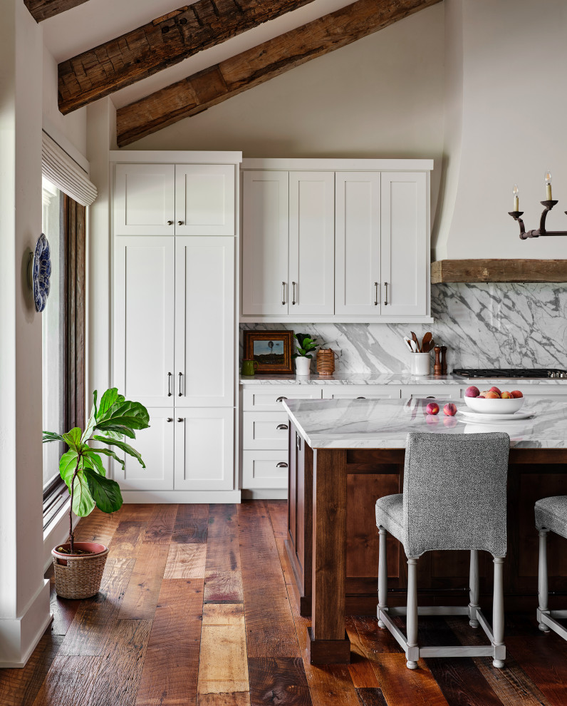 Design ideas for an expansive country single-wall kitchen in Austin with shaker cabinets, white cabinets, stainless steel appliances, medium hardwood floors, with island and exposed beam.