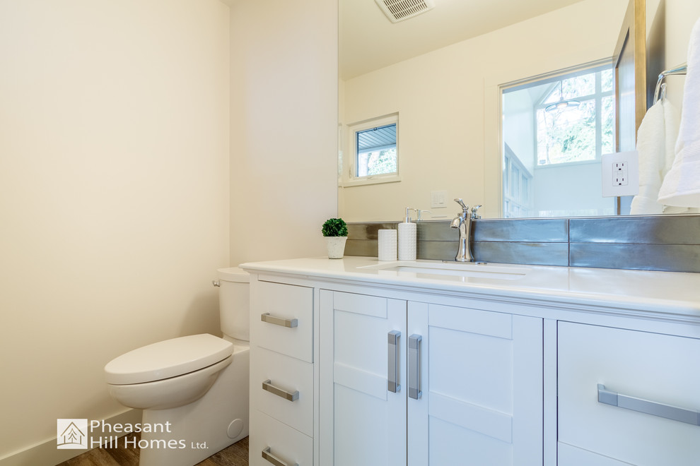 Inspiration for a small contemporary 3/4 white tile and ceramic tile laminate floor and beige floor bathroom remodel in Vancouver with shaker cabinets, white cabinets, a one-piece toilet, white walls, an undermount sink and quartz countertops