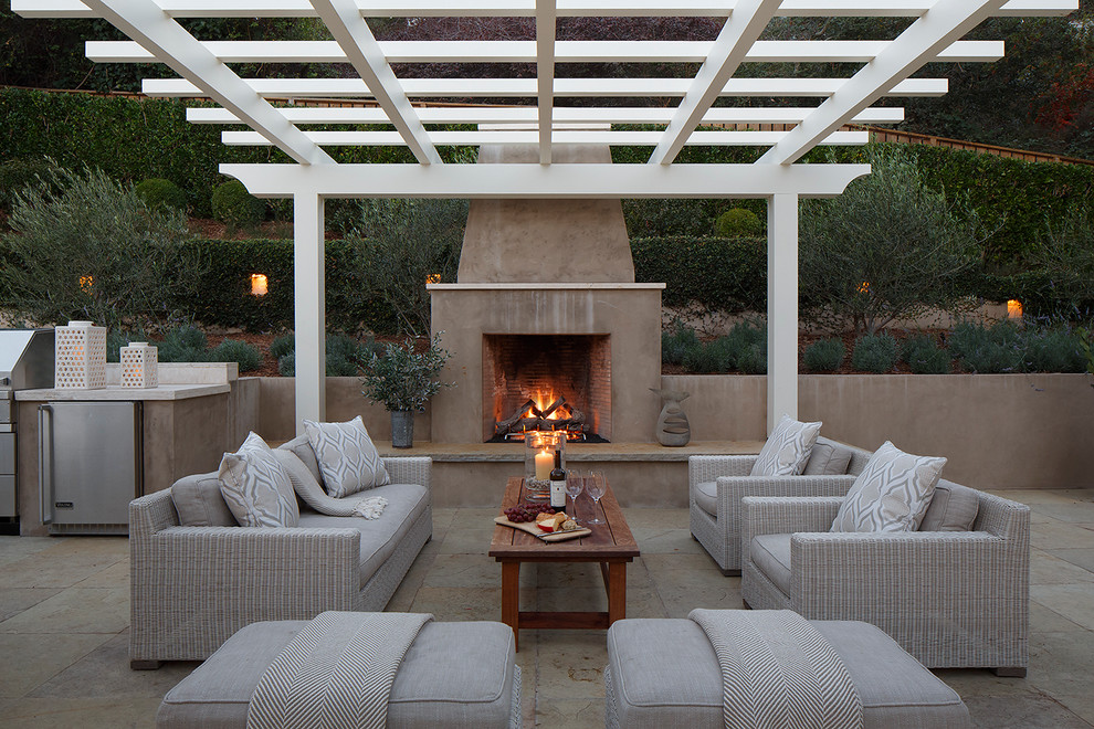 This is an example of a transitional backyard patio in San Francisco with natural stone pavers, a pergola and with fireplace.