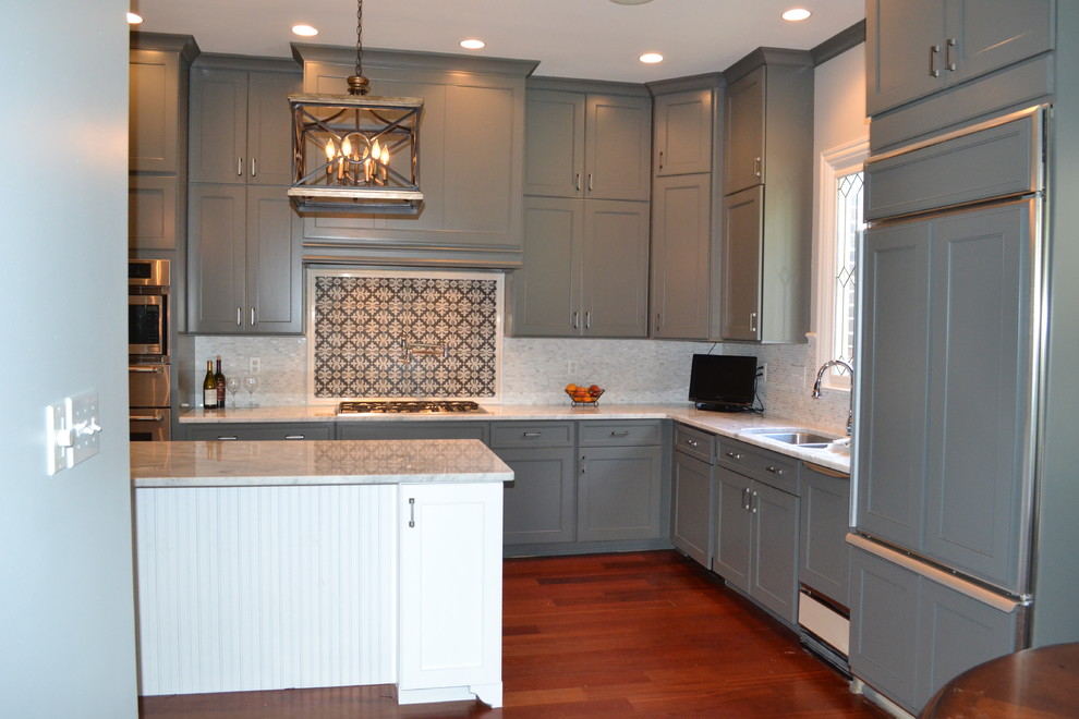 Example of a mid-sized transitional l-shaped dark wood floor eat-in kitchen design with shaker cabinets, a double-bowl sink, gray cabinets, marble countertops, multicolored backsplash, cement tile backsplash, paneled appliances and a peninsula