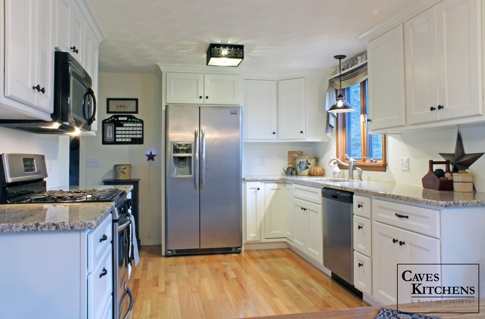 Example of a small transitional u-shaped medium tone wood floor eat-in kitchen design in New York with an undermount sink, recessed-panel cabinets, white cabinets, granite countertops, white backsplash, stainless steel appliances and no island