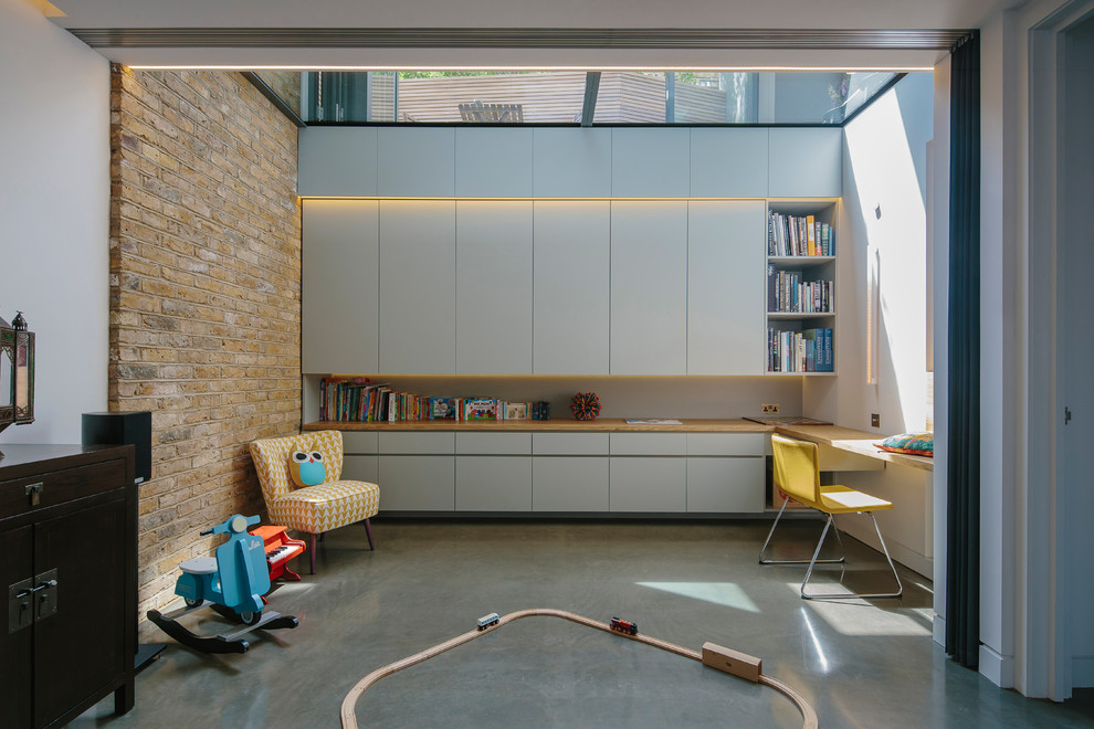 Contemporary gender-neutral kids' playroom in London with concrete floors and white walls.