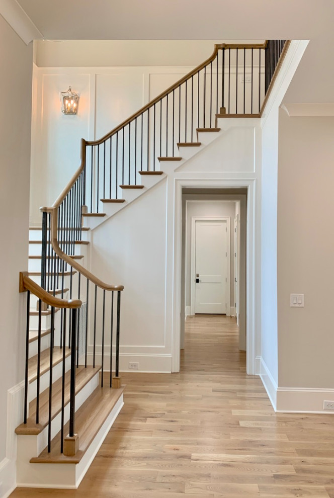 Inspiration for a large traditional wood u-shaped staircase in Charlotte with painted wood risers, wood railing and decorative wall panelling.