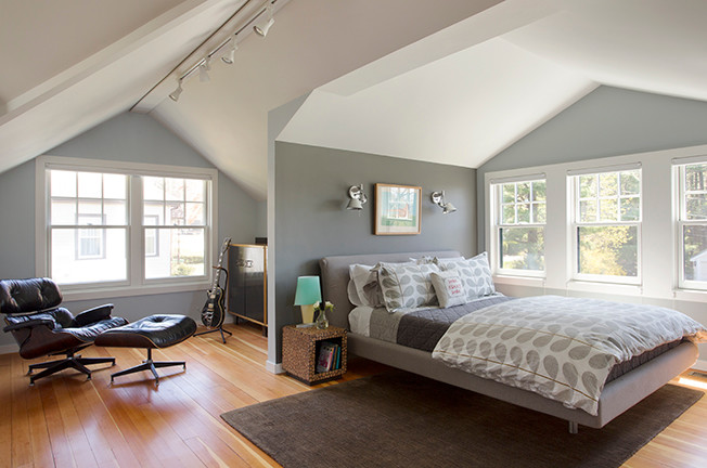 Small modern loft-style bedroom in Boston with grey walls and medium hardwood floors.