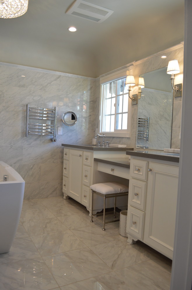 Mid-sized transitional master bathroom in Los Angeles with recessed-panel cabinets, white cabinets, a freestanding tub, a corner shower, a bidet, gray tile, porcelain tile, grey walls, porcelain floors, an undermount sink and quartzite benchtops.
