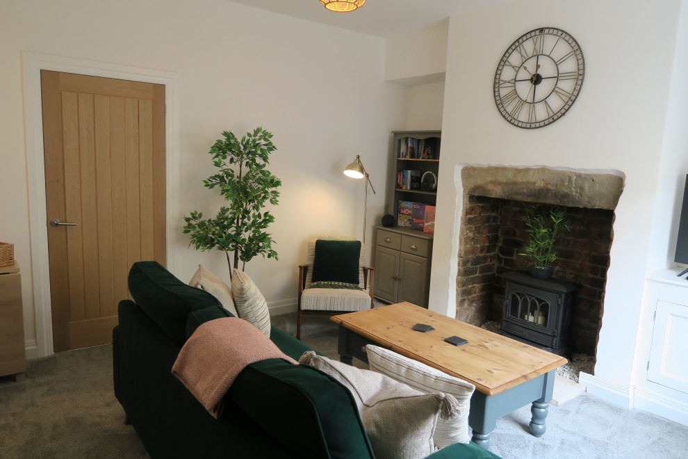 Immagine di un piccolo soggiorno chic chiuso con pareti bianche, moquette, cornice del camino in pietra, TV autoportante e pavimento grigio