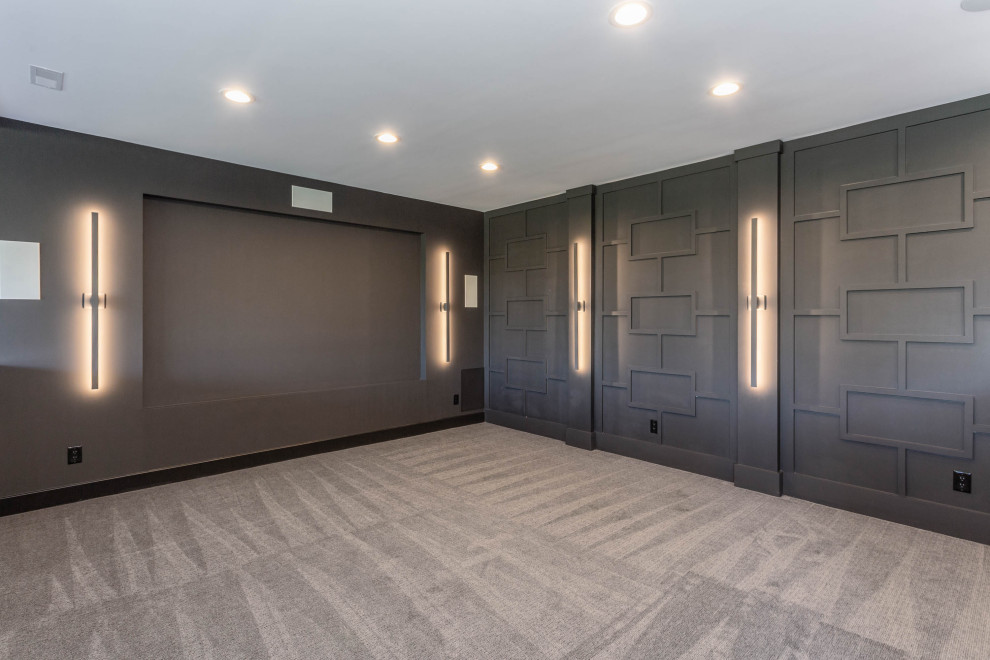 Large modern open concept home theatre in Indianapolis with grey walls, carpet and beige floor.