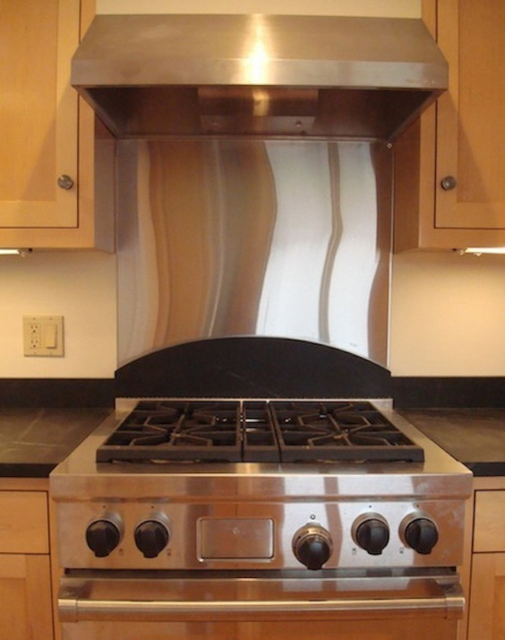 Eat-in kitchen - mid-sized l-shaped medium tone wood floor eat-in kitchen idea with a farmhouse sink, medium tone wood cabinets, solid surface countertops, stainless steel appliances and an island