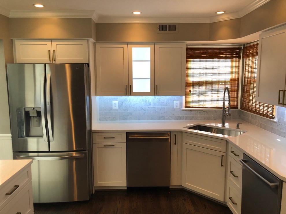 Mid-sized transitional u-shaped dark wood floor and brown floor eat-in kitchen photo in DC Metro with an undermount sink, recessed-panel cabinets, white cabinets, quartz countertops, white backsplash, marble backsplash, stainless steel appliances, an island and white countertops