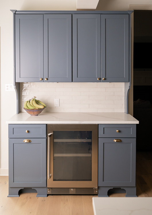 Eat-in kitchen - large transitional u-shaped light wood floor, brown floor and vaulted ceiling eat-in kitchen idea with an undermount sink, shaker cabinets, white cabinets, quartz countertops, white backsplash, porcelain backsplash, stainless steel appliances, an island and white countertops