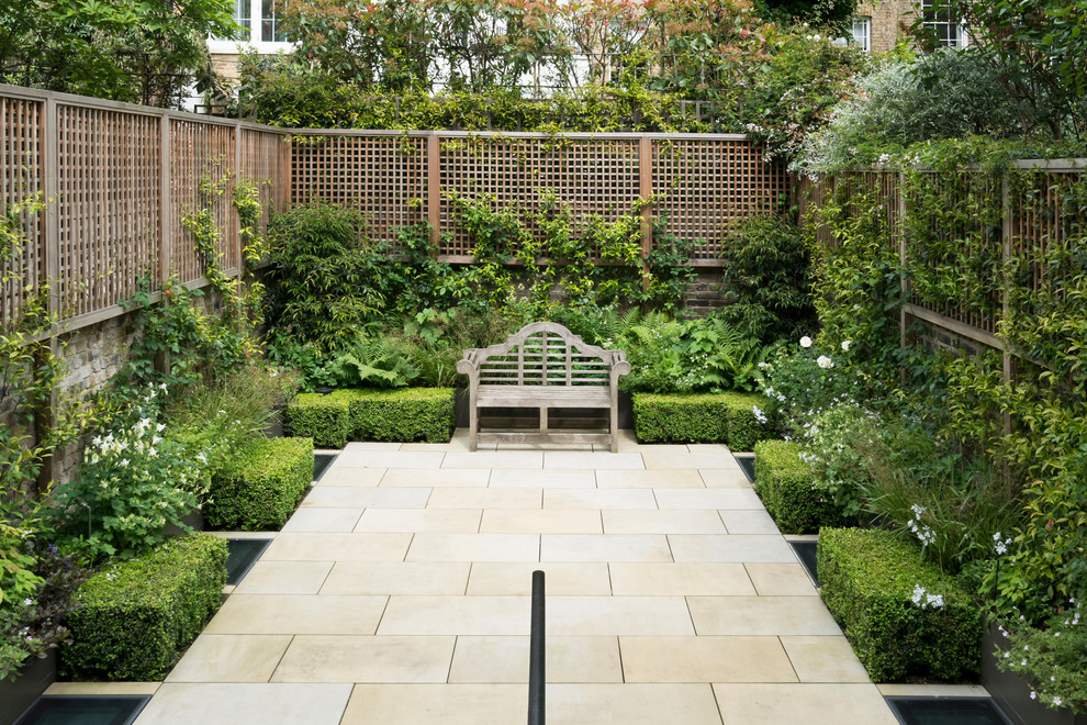 Photo of a mid-sized traditional backyard garden in London.