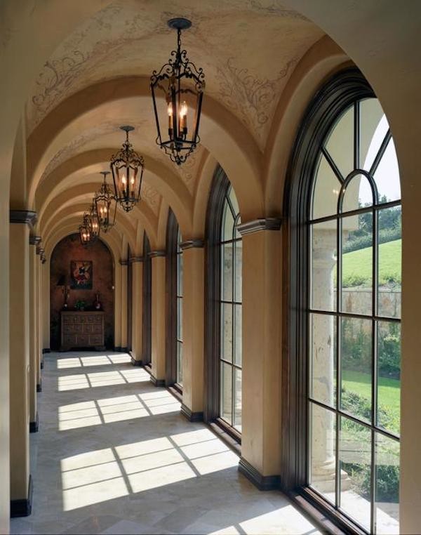 This is an example of a large mediterranean hallway in Austin with yellow walls and beige floor.