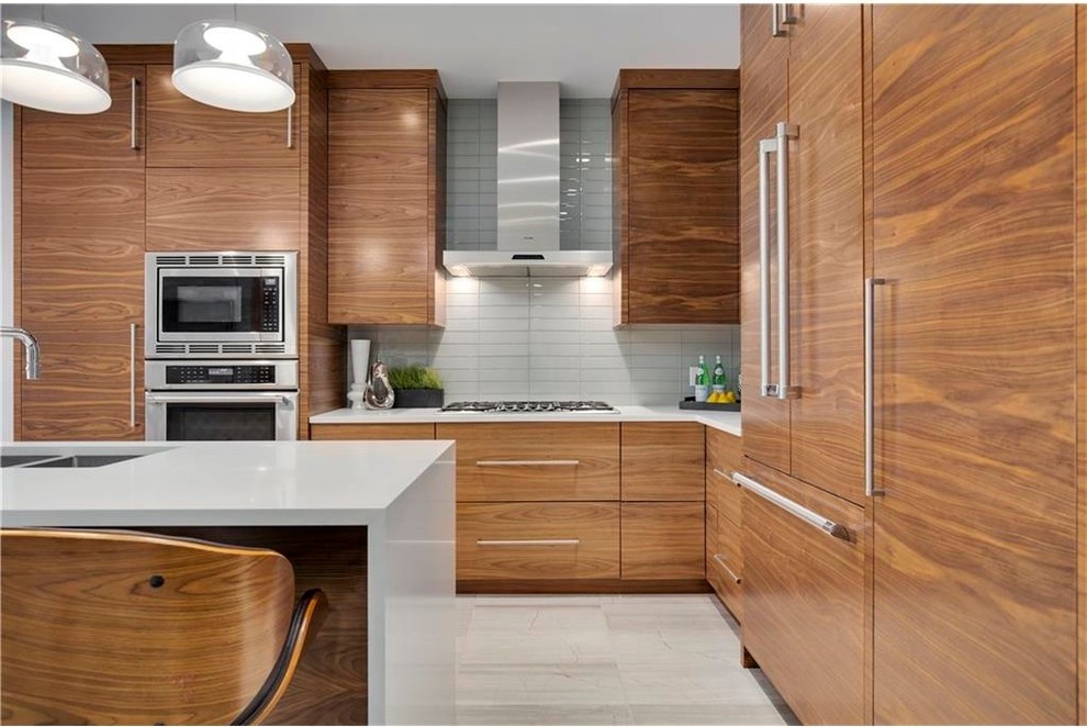 Inspiration for a mid-sized modern l-shaped eat-in kitchen in Vancouver with an undermount sink, flat-panel cabinets, medium wood cabinets, quartzite benchtops, white splashback, porcelain splashback, panelled appliances, porcelain floors and with island.