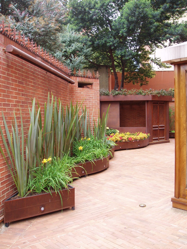 Inspiration for a contemporary patio in London with brick pavers.