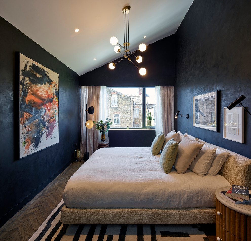 This is an example of a large contemporary master bedroom in London with black walls, medium hardwood floors, brown floor and vaulted.