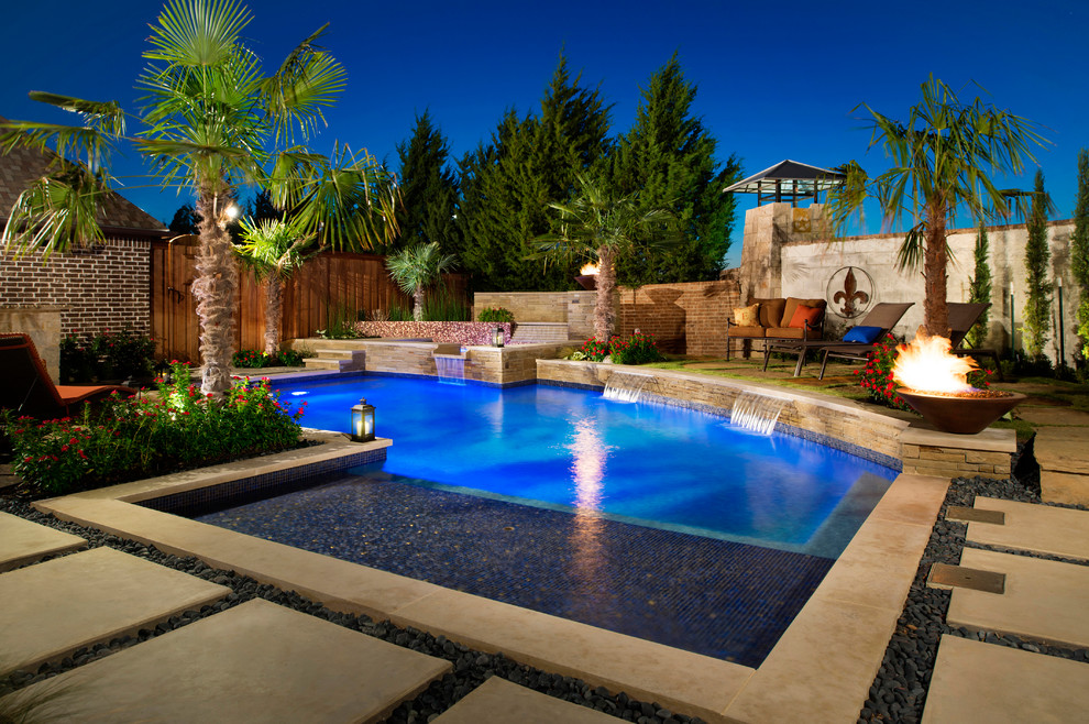 This is an example of a mid-sized modern backyard custom-shaped pool in Dallas with concrete pavers and a hot tub.