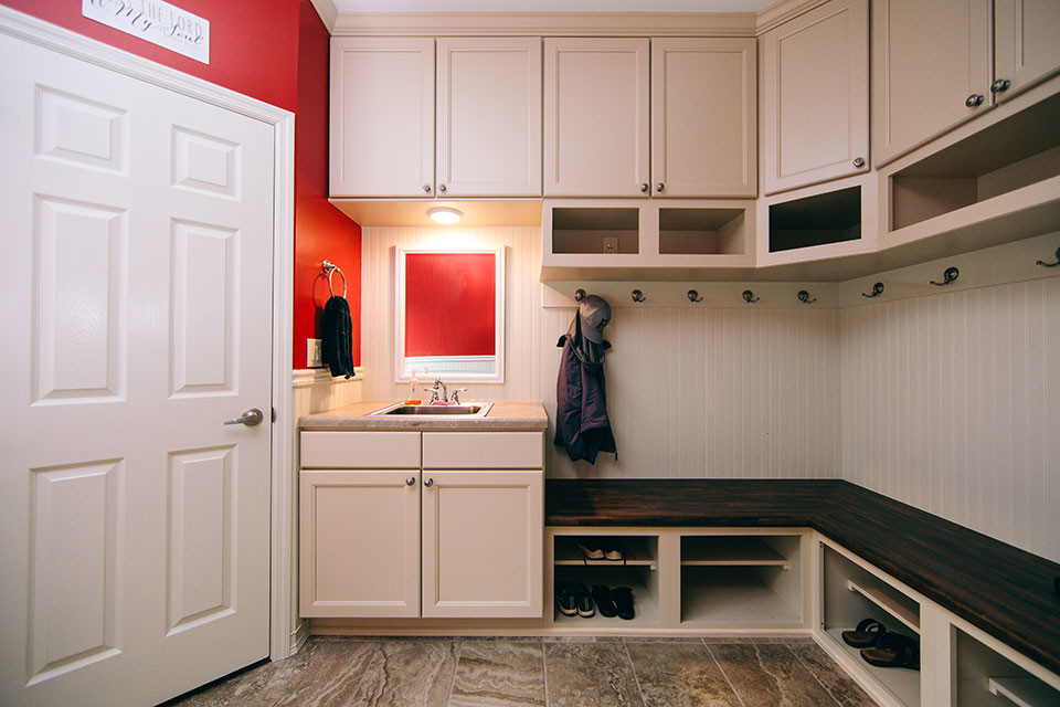 This is an example of a mid-sized transitional u-shaped utility room in Other with a single-bowl sink, recessed-panel cabinets, white cabinets, red walls, porcelain floors, a side-by-side washer and dryer, brown floor and beige benchtop.