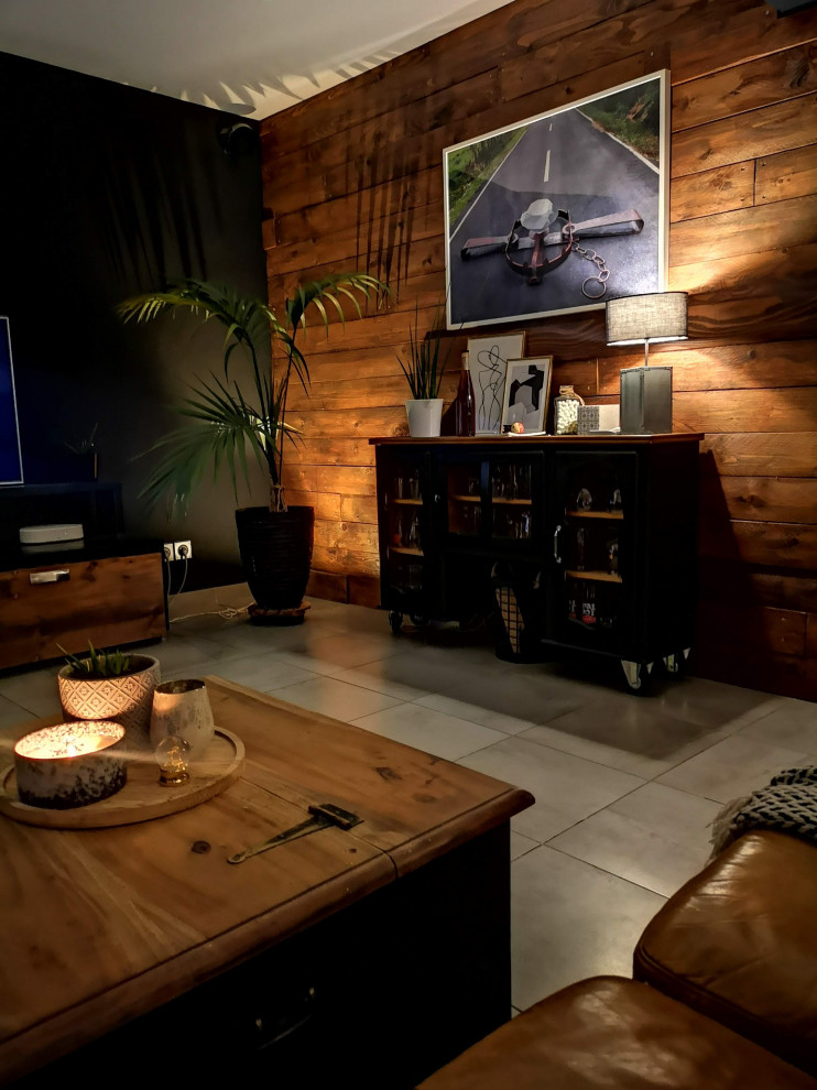 Immagine di un soggiorno industriale di medie dimensioni e aperto con pareti nere, TV a parete, pavimento grigio e pareti in legno