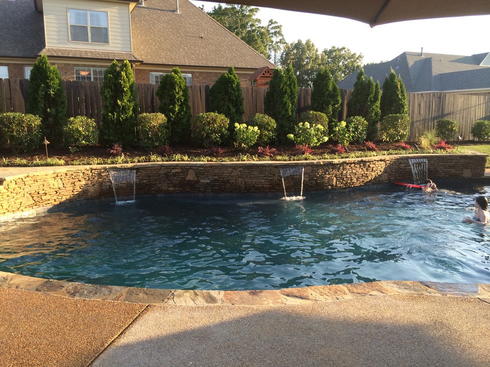 Inspiration for a large tropical backyard concrete and custom-shaped lap pool fountain remodel