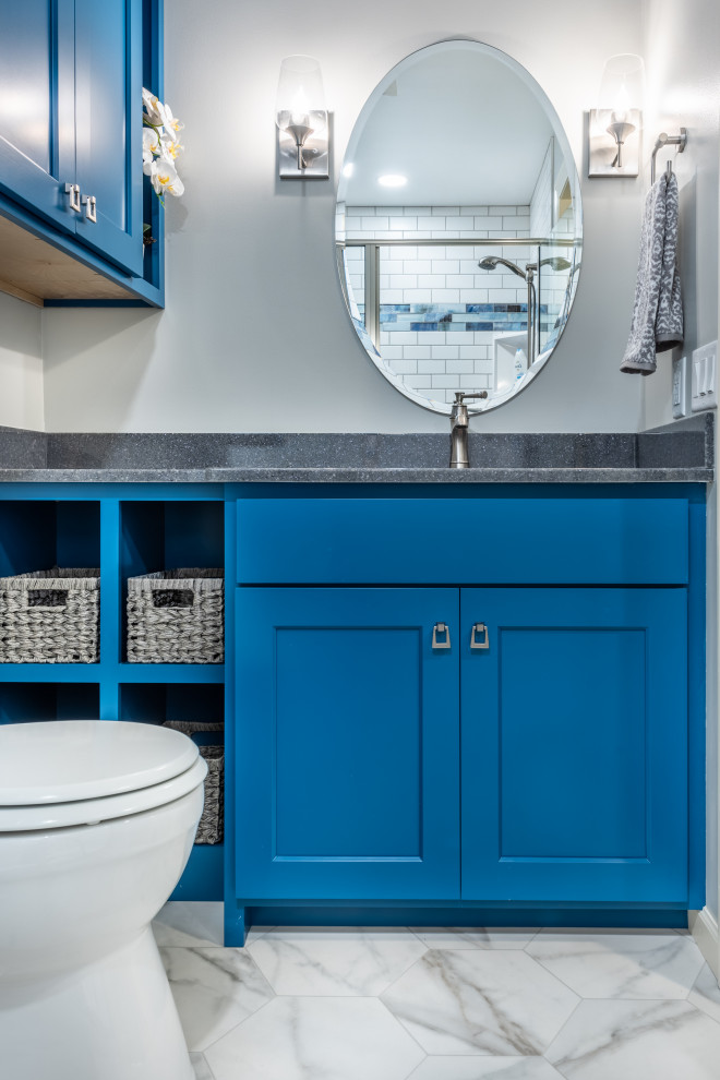 This is an example of a small transitional 3/4 bathroom in Other with blue cabinets, an alcove shower, a two-piece toilet, white tile, subway tile, grey walls, vinyl floors, an integrated sink, onyx benchtops, white floor, a sliding shower screen, grey benchtops, a single vanity and a built-in vanity.