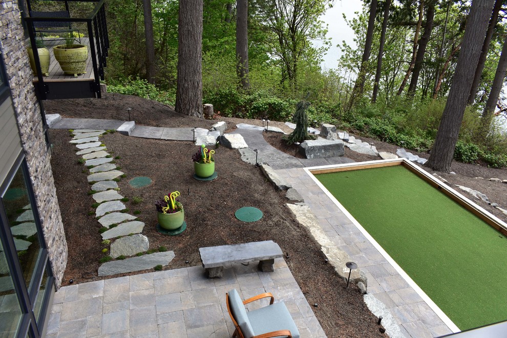 Midcentury backyard partial sun garden in Seattle with natural stone pavers and a garden path.